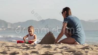 妈妈和她的小女儿在沙滩上玩水