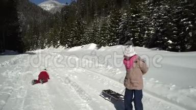 冬天，两个快乐美丽的孩子在雪山上<strong>玩</strong>着有趣的雪橇。 <strong>兄弟</strong>和<strong>兄弟</strong>