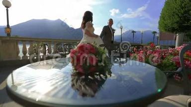 快乐的新娘和新郎在夏天的露台上<strong>散步</strong>和<strong>牵手</strong>。 意大利科莫湖