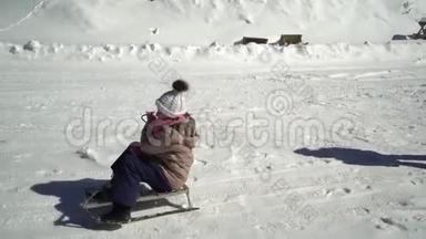 冬天，两个快乐美丽的孩子在雪山上玩着有趣的雪橇。 兄弟和兄弟