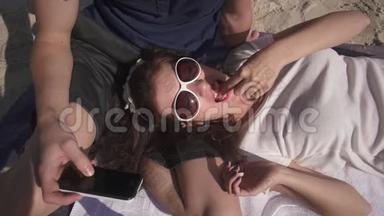 奢侈的生活理念。 在炎热的夏日，在海滩上用葡萄酒和糖果放松野餐的情侣特写镜头