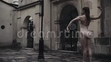 年轻的职业女<strong>舞蹈</strong>演员正在雨中世纪的街道上表演杂技<strong>舞蹈</strong>。 湿<strong>女孩</strong>