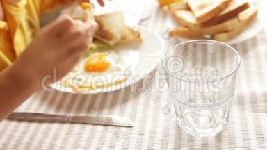 妈妈早晨给他的小儿子倒橙汁，早餐是煎鸡蛋