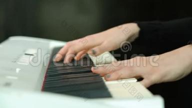 女子双手弹奏白色数字钢琴，特写镜头配合离焦.. 女孩用手指在键盘或
