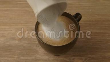 咖啡机在杯子里倒热牛奶，准备卡布奇诺