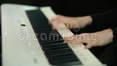 女子双手弹奏白色数字钢琴，特写镜头配合离焦.. 女孩<strong>用手指</strong>在键盘或