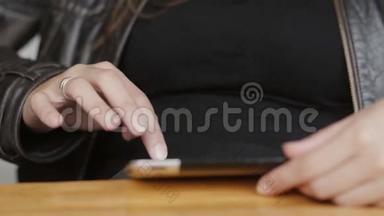 女孩双手特写用平板电脑在现代咖啡馆里上网。