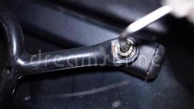 <strong>机修工</strong>用螺丝将车间内的黑色塑料和金属摩托车备件上的金属螺栓固定下来