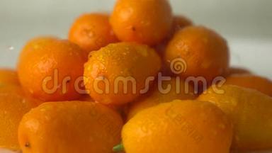 小水滴击中了一堆橙色的金橘。 超级慢动作视频
