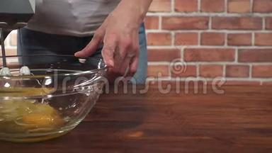 女人用搅拌器将鸡蛋搅拌成玻璃碗，超级慢动作高清视频