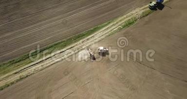 空中全景视频从无人驾驶的农田，拖拉机与犁耕土地播种作物在