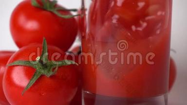一些红西红柿和西红柿汁倒入玻璃杯中。 超级慢动作