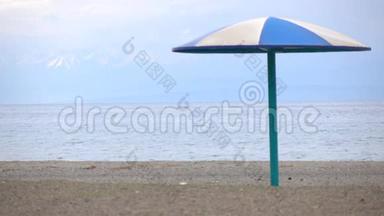 空的沙滩和蓝色的太阳伞迎着雪峰.. 4K低季视频