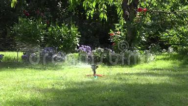 洒水车<strong>浇水</strong>工具喷水水滴喷在花园<strong>草坪</strong>和鲜花上.. 4K