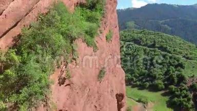粉红色岩石的空中视频，缺乏植被和遥远的积雪覆盖的山峰
