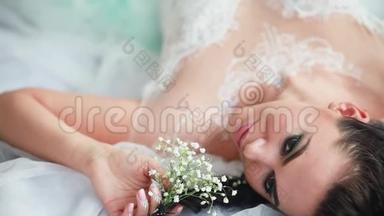 新娘穿着婚纱坐在椅子上。 那女孩正在为她的婚礼<strong>做准备</strong>