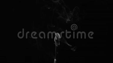 现实的抽象烟雾蒸气效应从底部。 白色烟雾在黑色背景上缓慢运动。 漂浮的雾云。