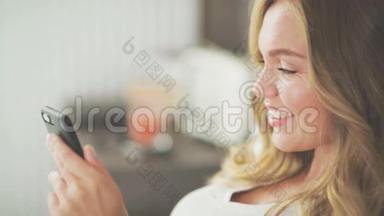 一个在轻床上用智能手机输入信息的漂亮女人。
