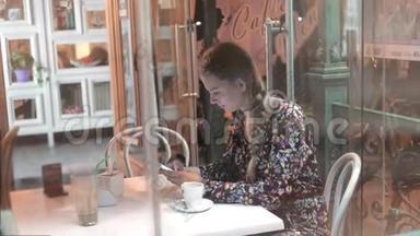 通过咖啡屋窗口观看与<strong>城市倒影</strong>的女人正在使用手机，。 智能手机的年轻学生