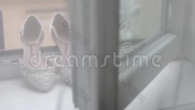 新娘婚礼漂亮的鞋子在白色的窗户上，豪华的高跟鞋特写