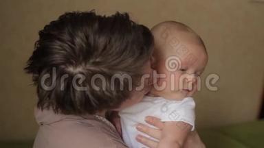 年轻漂亮的妈妈用爱亲吻她的小宝宝