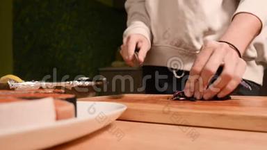 一个女孩的手特写在家厨房的一块木制砧板上小樱桃西红柿。<strong>家常菜</strong>