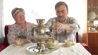 一对老夫妇用一个老式的俄罗斯水壶萨莫瓦尔准备茶。 一个留胡子的男人给妻子倒茶