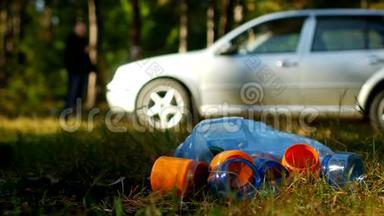 <strong>一包</strong>带塑料瓶的垃圾躺在大自然上，背景中有<strong>一</strong>辆车，人们都是