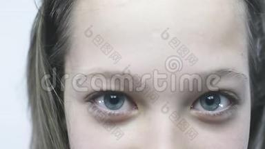 一个年轻女孩蓝色眼睛的特写肖像。 一个长着大眼睛的漂亮女孩正站在雨中。