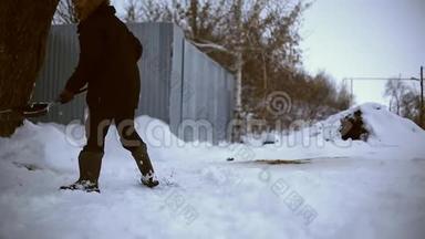 雪夜后工作.. 在一个寒冷的雪天早晨，一个拿着铲子把雪从他的院子里移走的人。