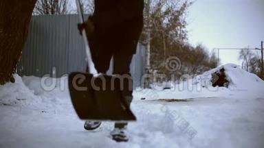 雪夜后工作.. 在一个寒冷的雪天早晨，一个拿着铲子把雪从他的院子里移走的人。