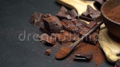 深色巧克力块和可可粉放在深色混凝土背景下的木碗里