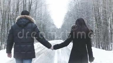 女孩和男孩沿着<strong>马路</strong>走进树林。 握住手