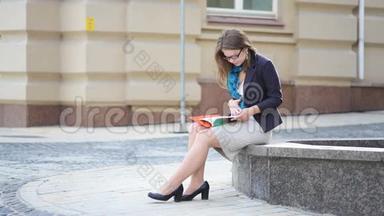 年轻女子在城市公园看书。 学生小女孩在看书