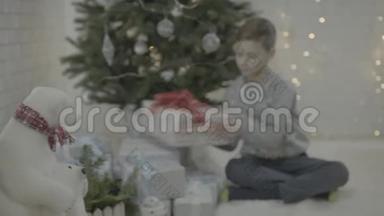 欢乐的小男孩打开圣诞礼物新年树节日气氛室内打开圣诞礼物盒