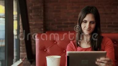 女人用平板电脑触摸屏，在咖啡馆喝茶