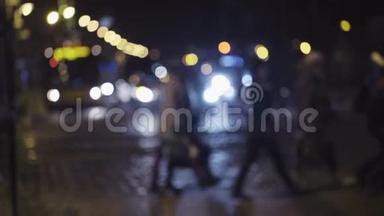 市中心<strong>夜间</strong>交通的慢镜头。 行人在人行横道上穿过<strong>街道</strong>。 模糊的图像