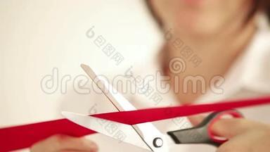 女人用剪刀剪红带子