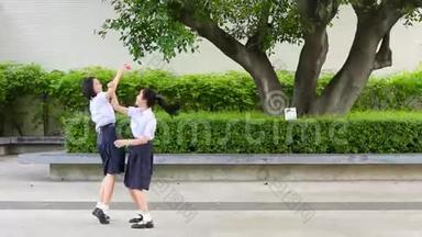 可爱的亚洲泰国<strong>高中</strong>女学生夫妇穿着校服，玩着追逐和捕捉娃娃玩得很开心