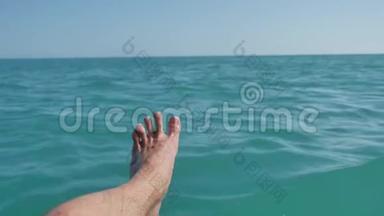 湿人脚踩在海水上。 人在船的边缘放松他的脚。 旅行概念。