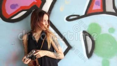 有<strong>纹身</strong>的女孩站在<strong>涂鸦</strong>墙和照片附近。