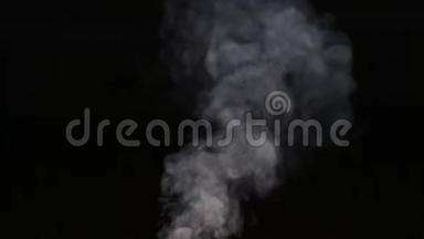 灰色的烟雾在黑色的背景上升起。 肥皂泡显示。