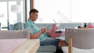 咖啡馆里使用平板电脑触摸屏的成熟男人