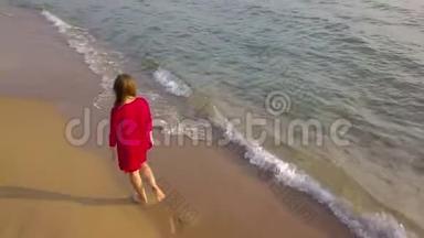 一个女人赤脚走在<strong>潮</strong>湿的沙滩上的俯视<strong>图</strong>。 海浪冲刷着沙滩上的脚印