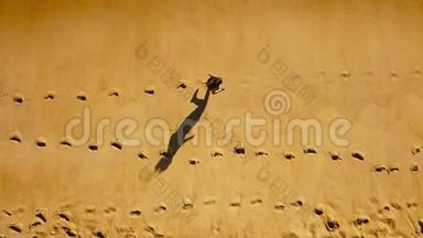 一位<strong>女子赤脚</strong>在潮湿的沙滩上奔跑的俯视图