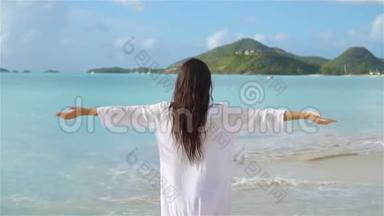 热带海滨的年轻美女。 快乐女孩的背景是蔚蓝的天空和<strong>碧蓝</strong>的海水