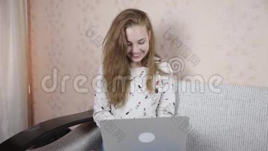年轻开朗，可爱的女孩使用笔记本电脑室内。