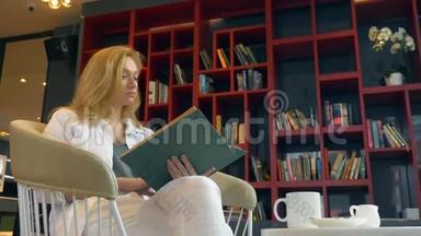 在书架背景下，年轻女子在图书馆看书