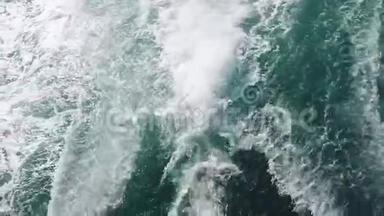 强大的波浪从快速移动的小船上拉出，一股巨大的深蓝水和白色泡沫上升。 慢动作