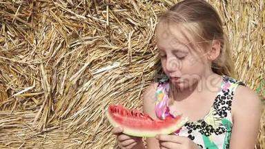 女孩在干草堆附近吃西瓜